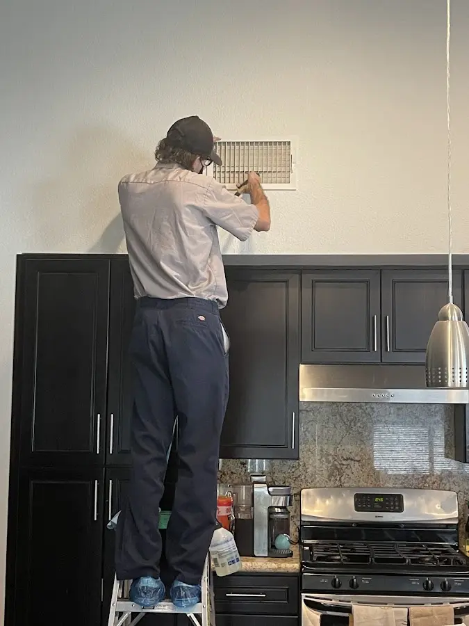 Technician inspecting an air vent during HVAC service in The Villages